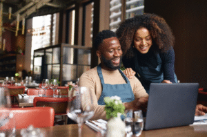 a couple of small business owners reviewing their numbers on a computer